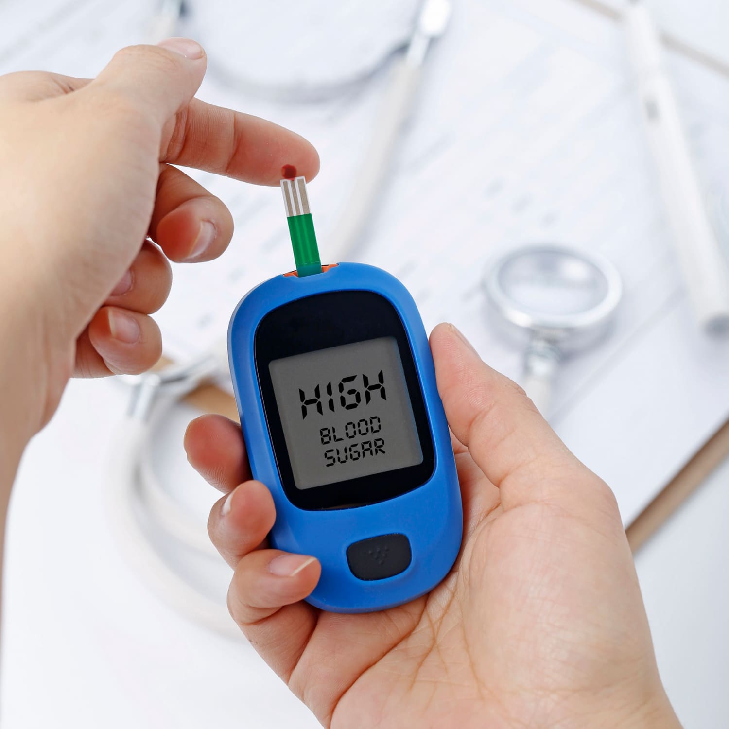 Tonic-WeightLoss-hand-holding-blood-glucose-meter-measuring-blood-sugar-background-is-stethoscope-chart-file